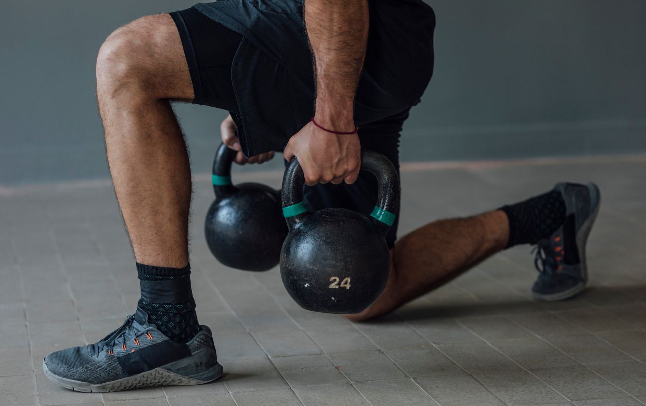 A person doing a kettlebell split squat.