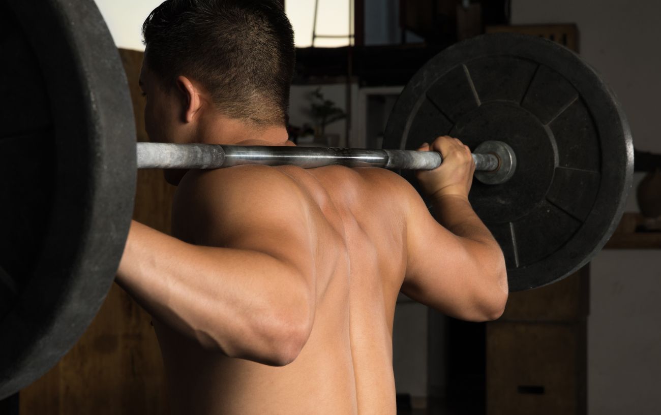 A person doing a back squat.