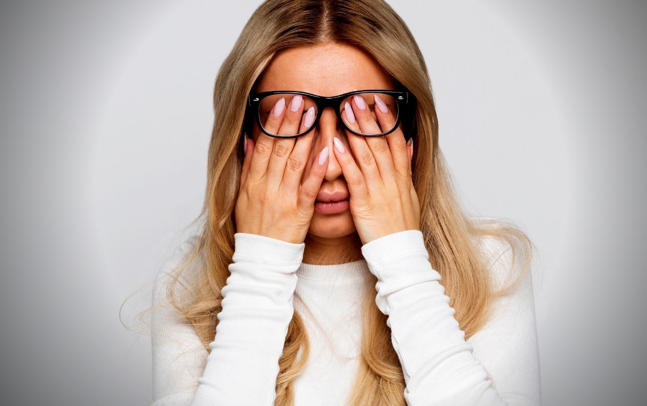 A person rubbing their eyes, fatigued.